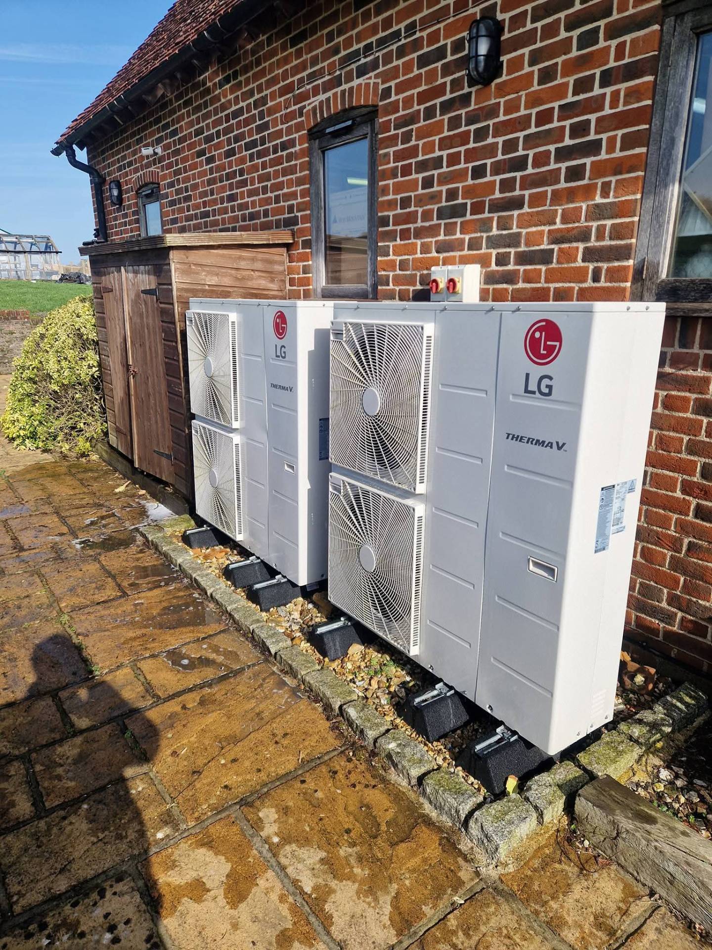 Mitsubishi Electric outdoor unit installed on a flat roof with weather protection