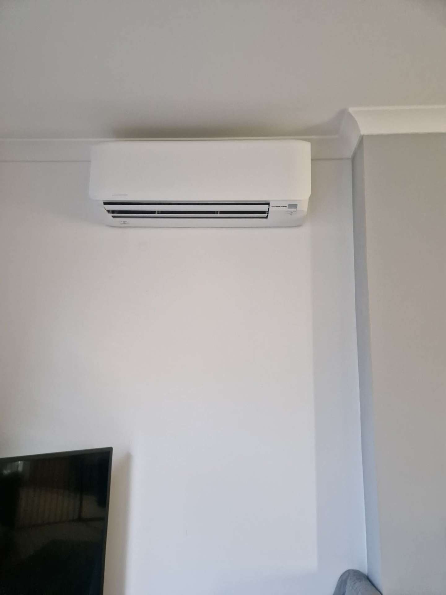 Wall-mounted split air conditioning unit providing cooling in a conservatory