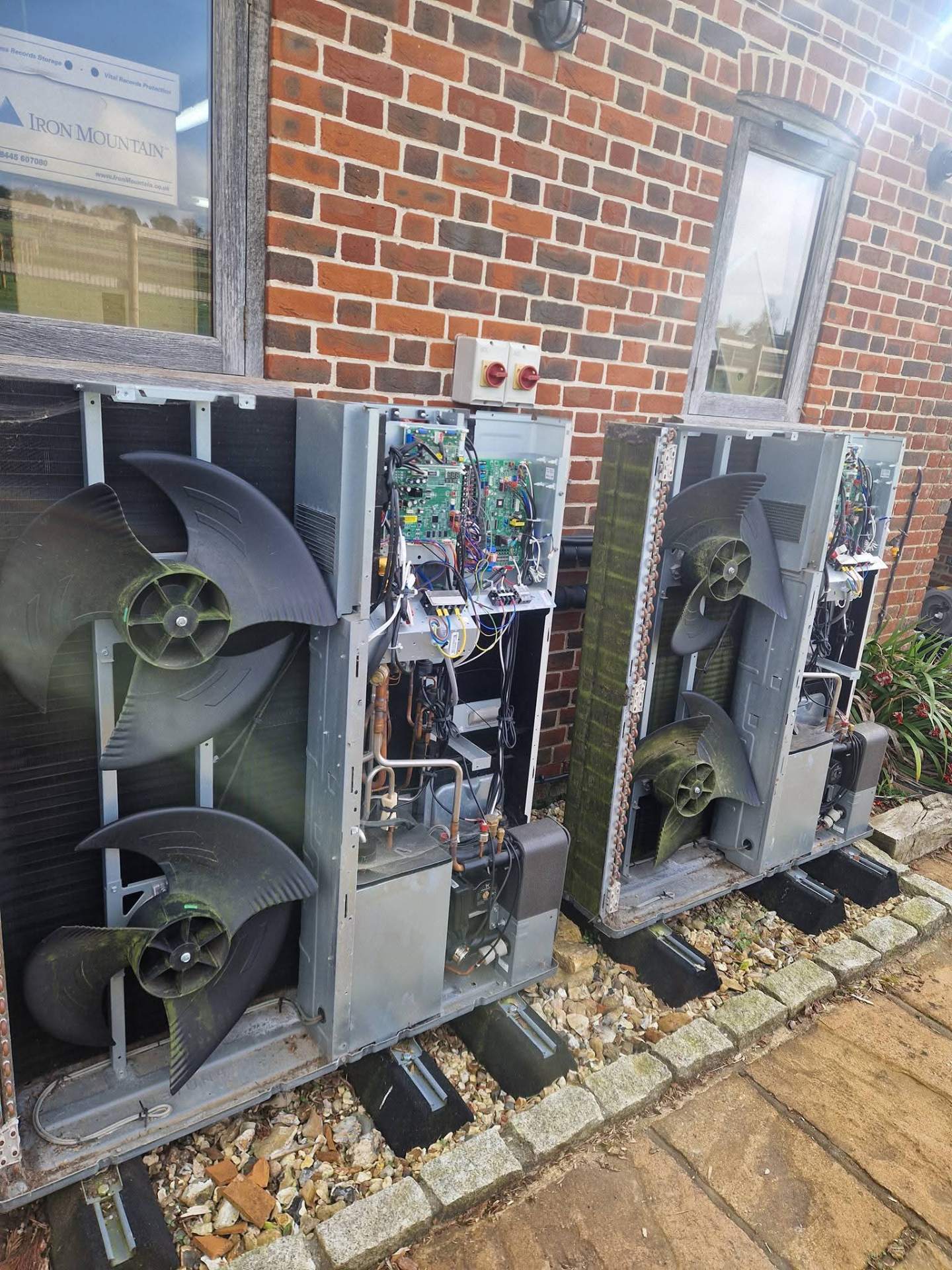 Completed heat pump installation showing outdoor unit with neatly routed pipework and electrical connections