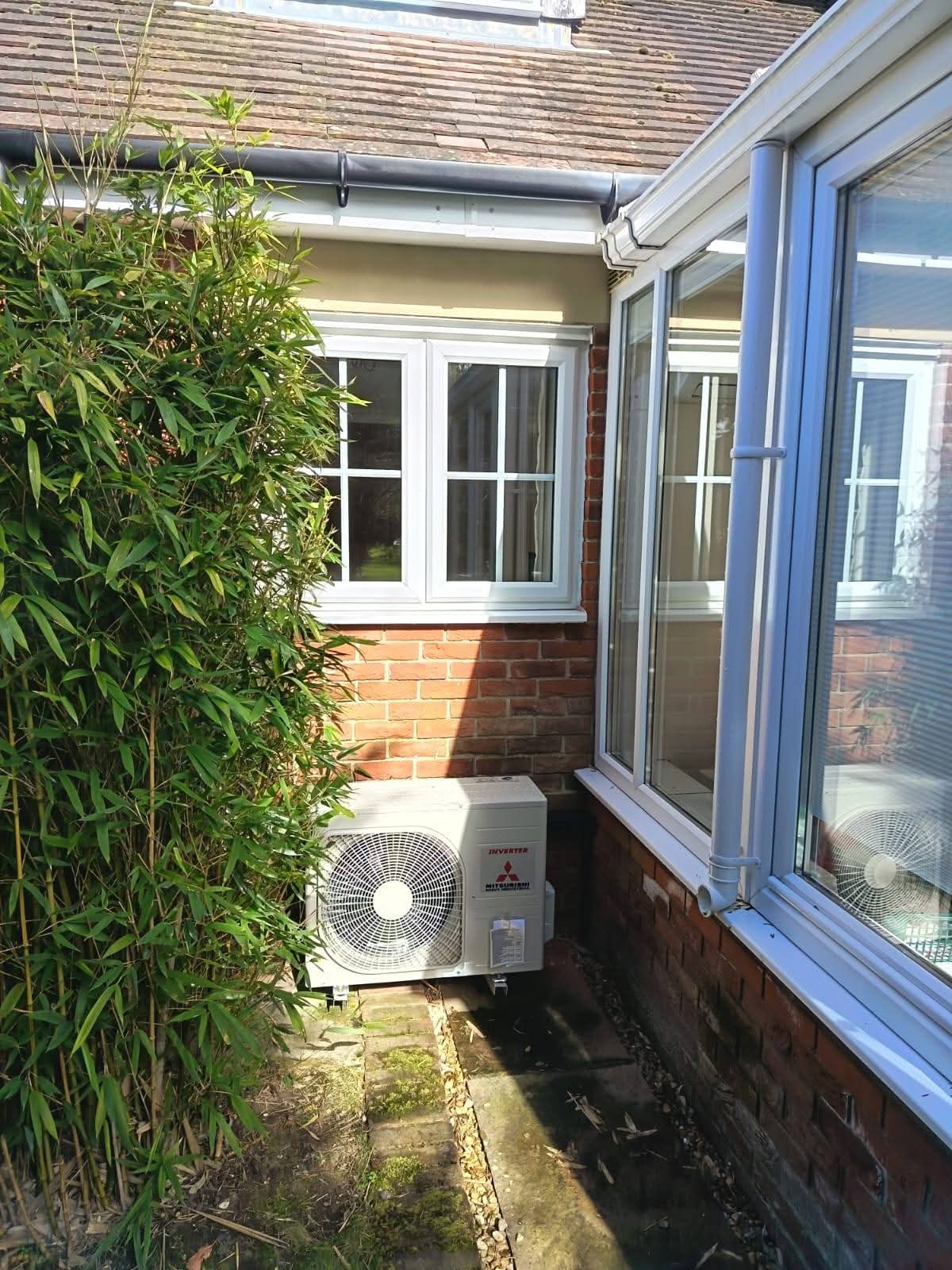 Air source heat pump positioned in rear garden with anti-vibration mounts and condensate drain
