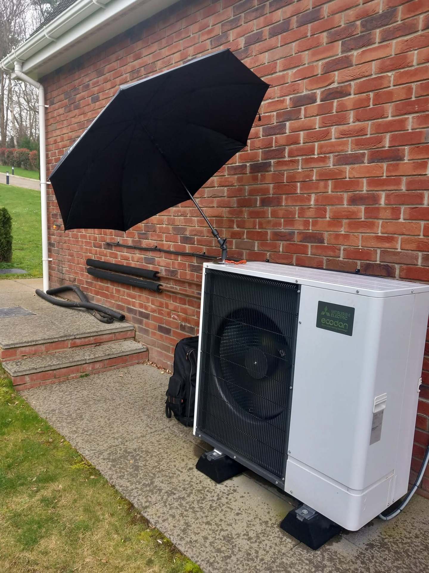 Mitsubishi Ecodan heat pump being serviced outdoors as part of annual maintenance contract