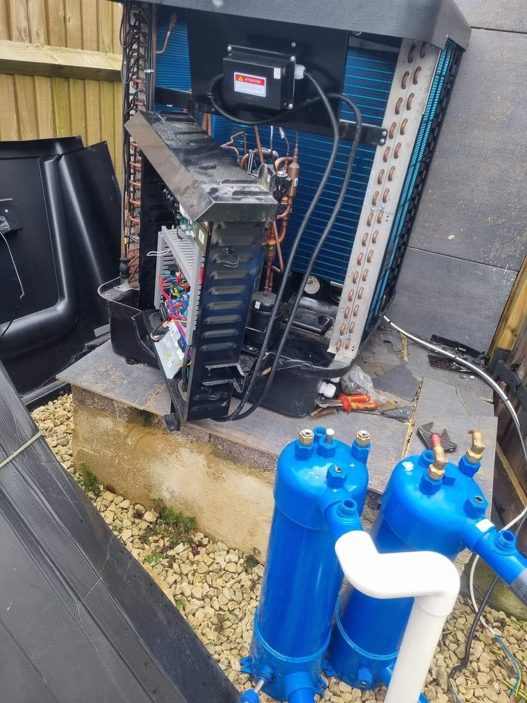 Pool heat pump compressor and PCB compartment opened for diagnostic inspection with filter drier and sight glass visible